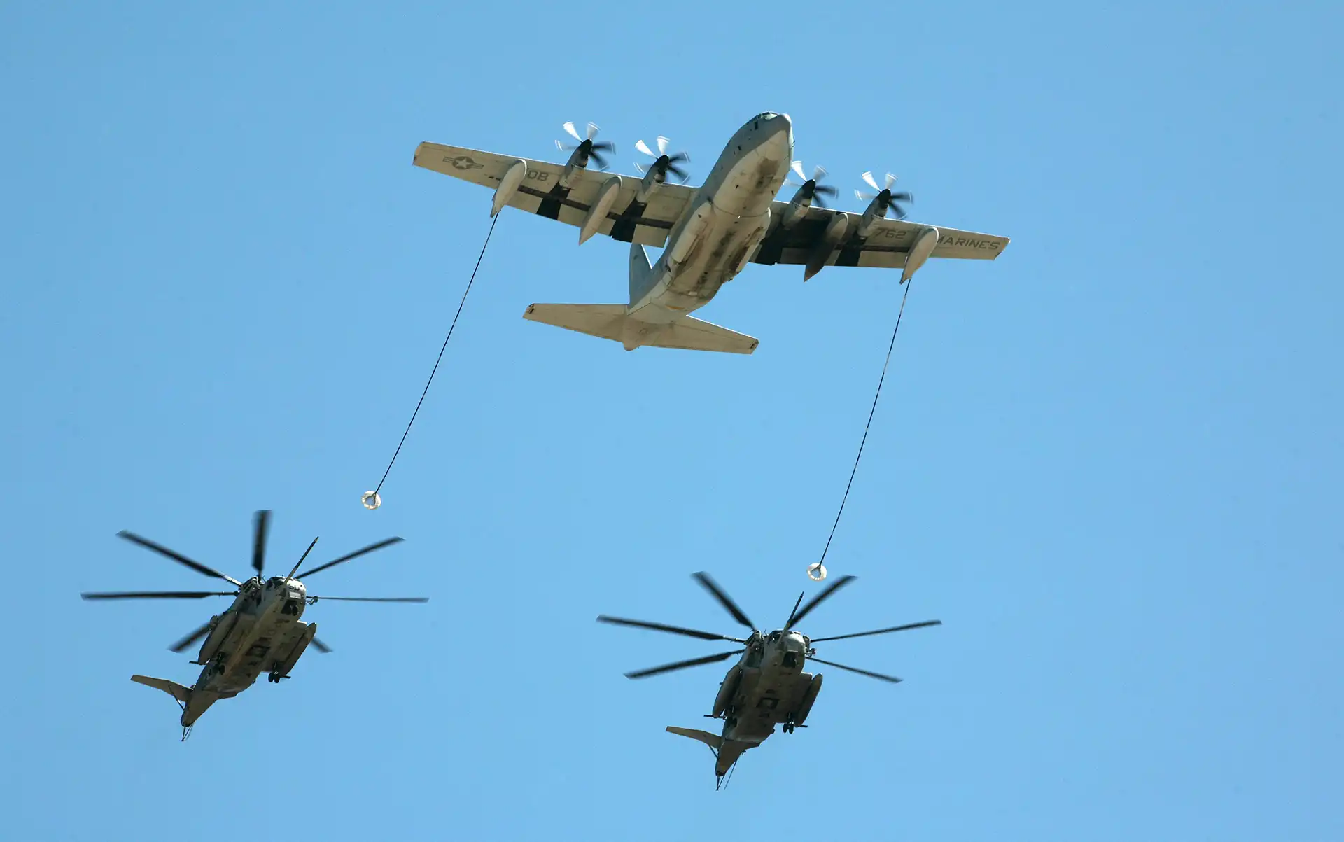 KC-130J tanker refueling two CH-53E helicopters
